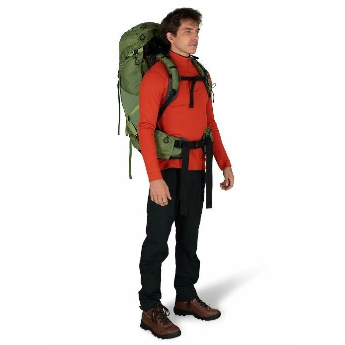 Man wearing a red shirt, black pants, and a green backpack on a white background