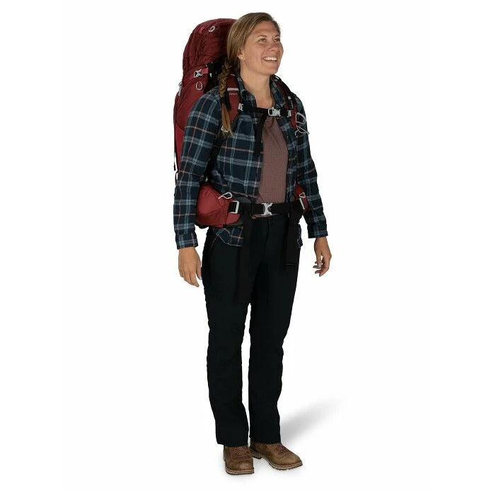 Person wearing a plaid shirt, black pants, and a red backpack on a white background
