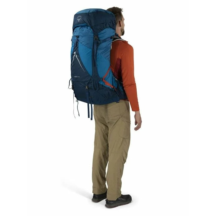 Person wearing a large blue backpack on a white background