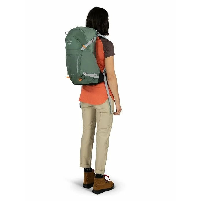 Person wearing a green and orange backpack on a white background