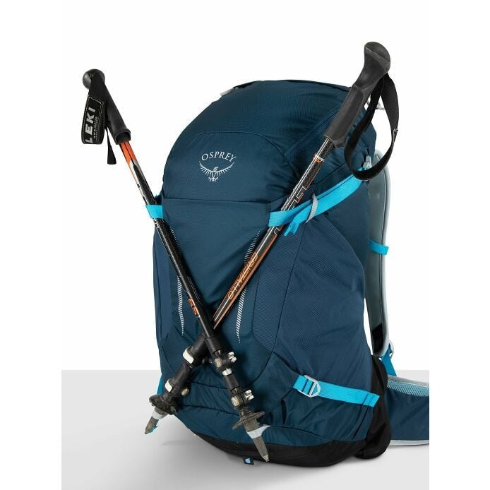 Blue Osprey backpack with hiking poles on a white background