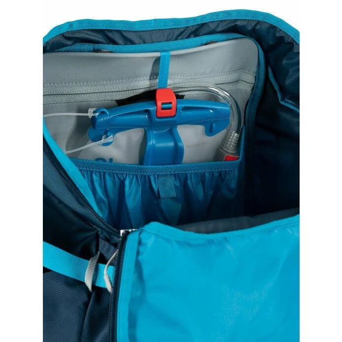 Blue backpack with a water bottle and accessories inside on a white background