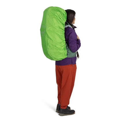 Person wearing a bright green backpack cover on a white background