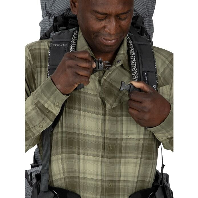 Man wearing a backpack with a visible Osprey logo, holding a lighter.