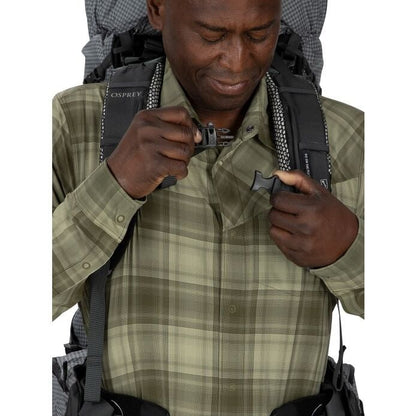 Man wearing a backpack with a visible Osprey logo, holding a lighter.