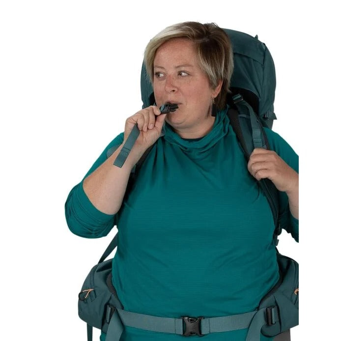 Person wearing a large green backpack and eating something from a pouch.