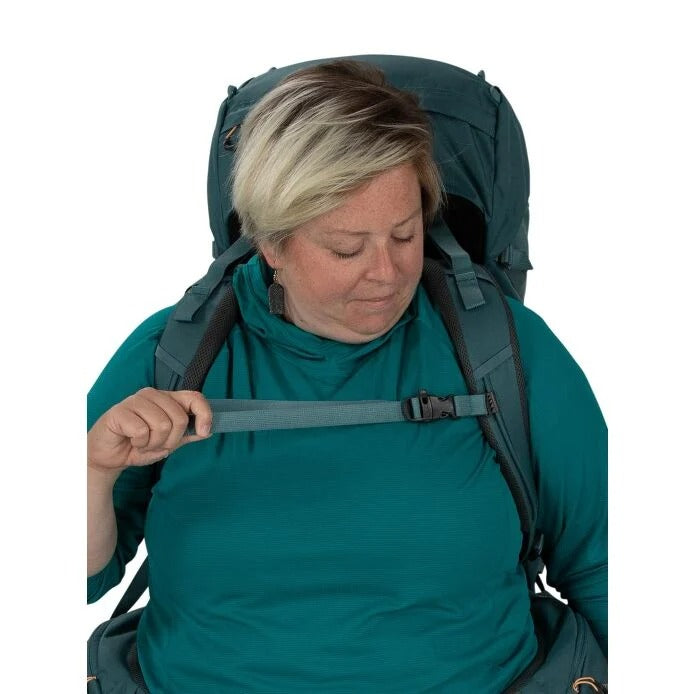 Person wearing a large green backpack on a white background