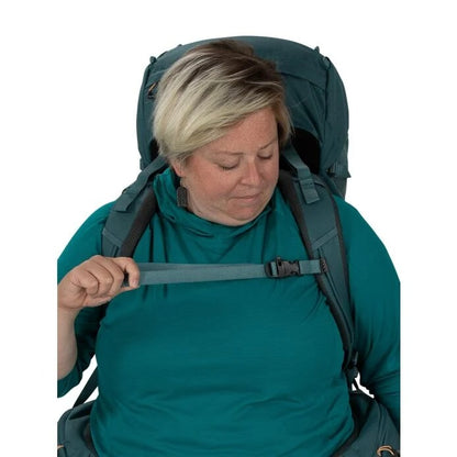 Person wearing a large green backpack on a white background