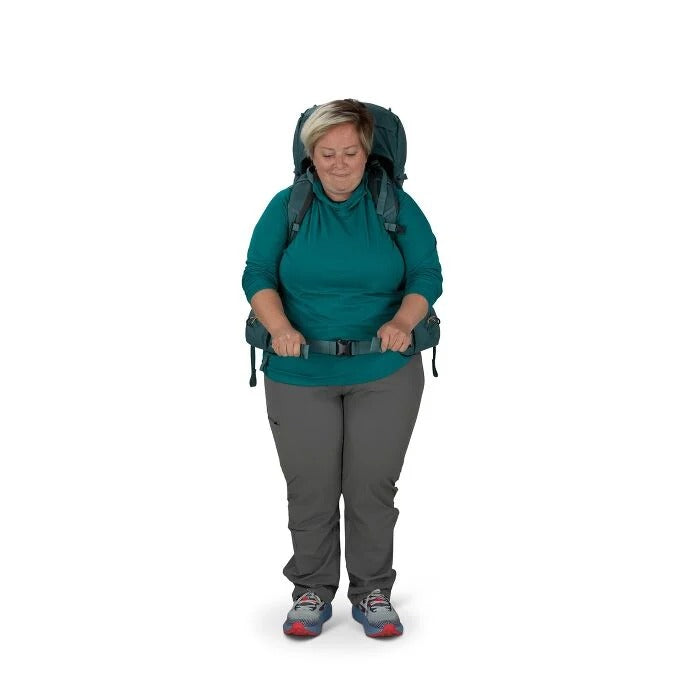 Person wearing a large green backpack on a white background
