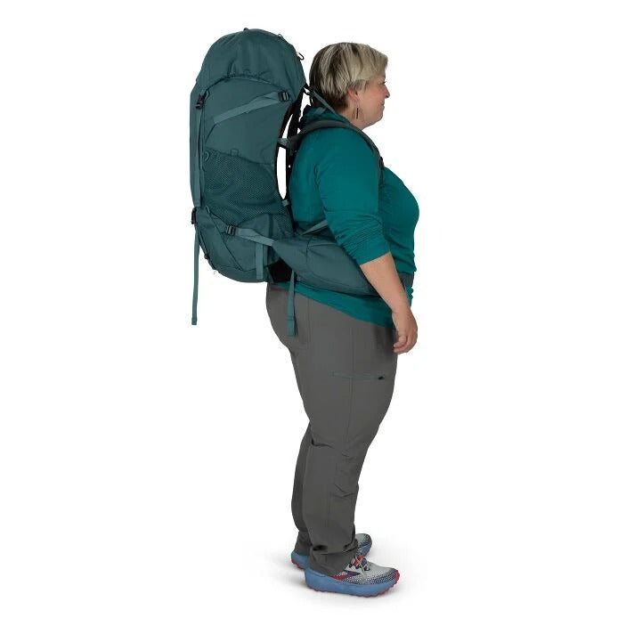 Person wearing a large green backpack on a white background