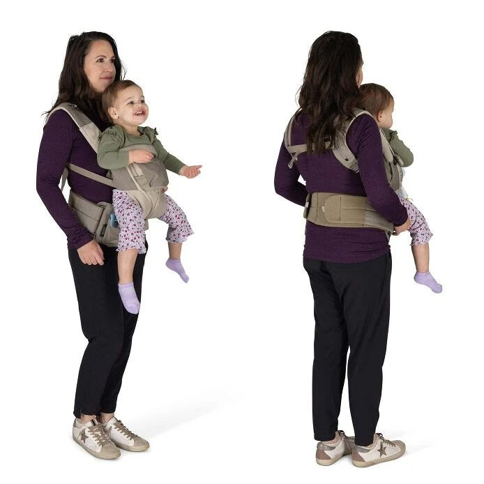 Woman using a baby carrier to hold a child on a white background
