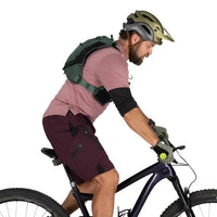 Man riding a bicycle wearing a helmet and backpack on a white background