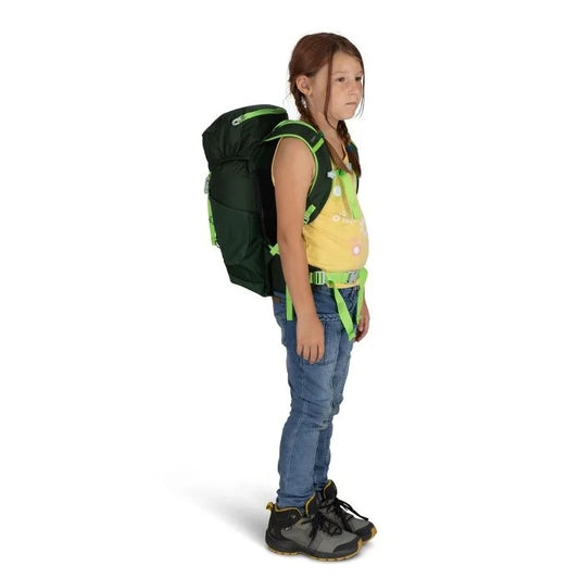 Child wearing a green and black backpack on a white background
