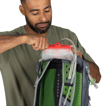 Man using a backpack with a hydration system on a white background
