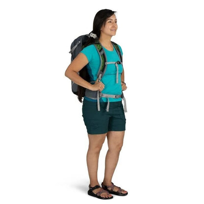 Woman wearing a hiking backpack on a white background