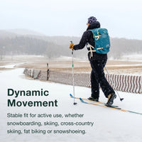 Person skiing in a snowy landscape with text about dynamic movement and product stability.