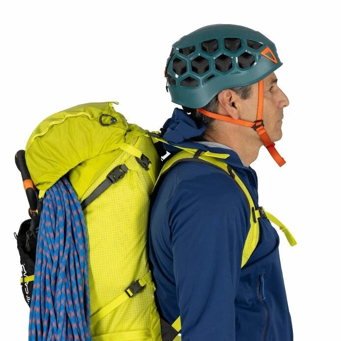 Person wearing a yellow backpack and blue climbing helmet on a white background