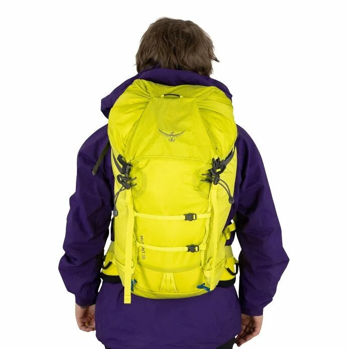 Person wearing a bright yellow backpack with a visible brand logo on a white background