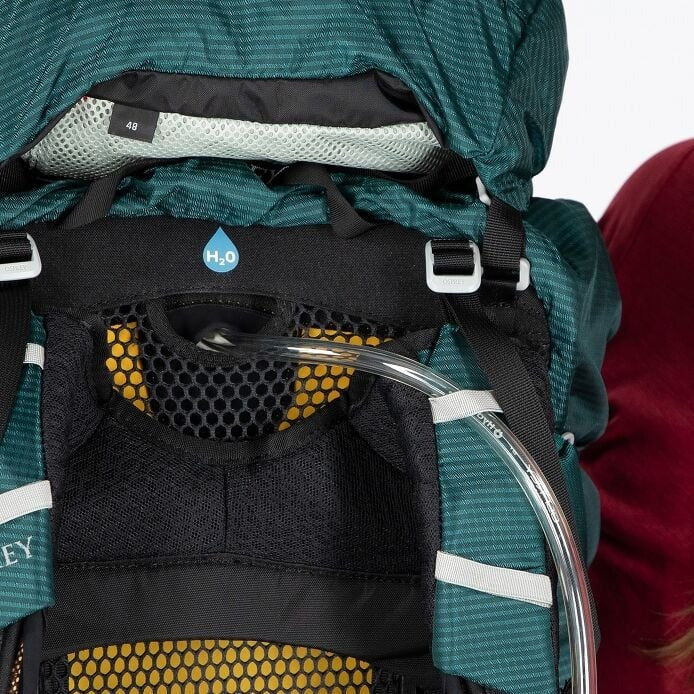 Close-up of a green backpack with water bottle holder and H2O logo.