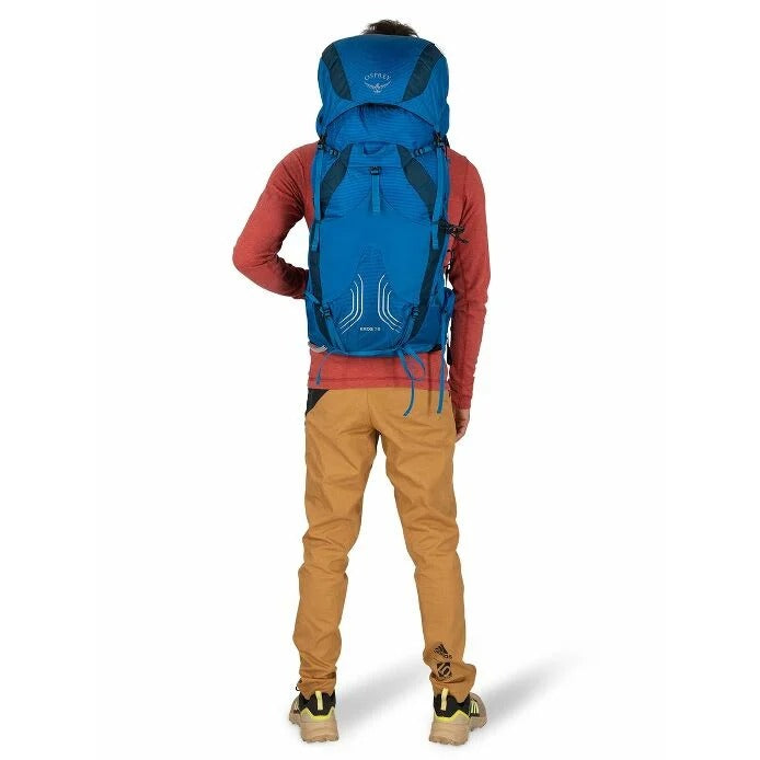 Person wearing a blue Osprey backpack on a white background