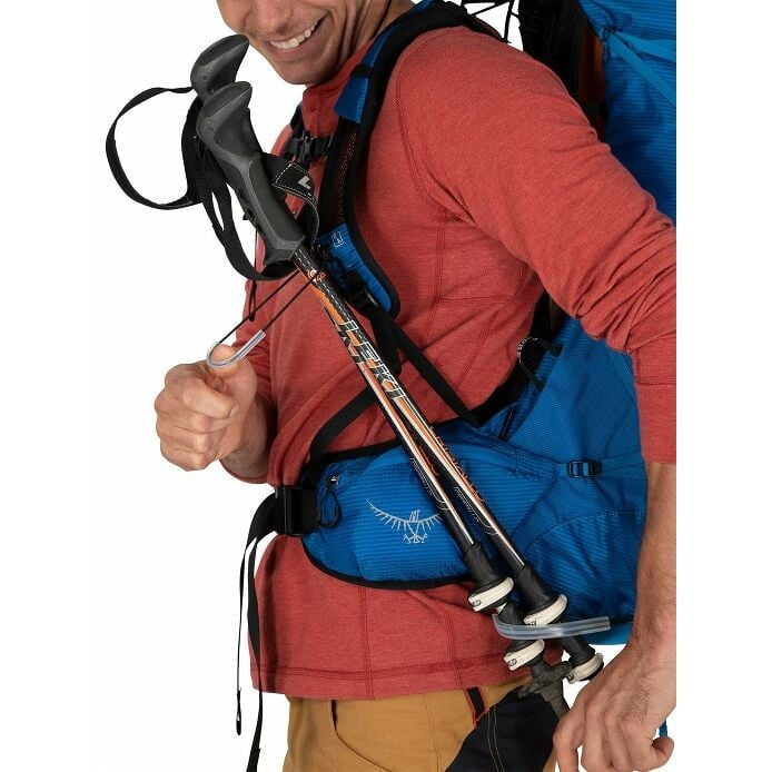 Person holding climbing poles with a blue backpack on a white background