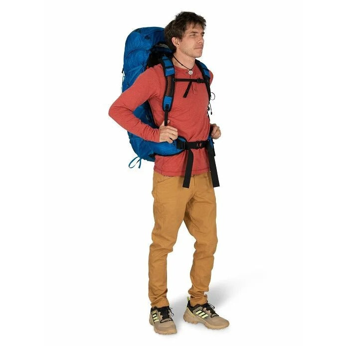 Man wearing a large blue backpack on a white background