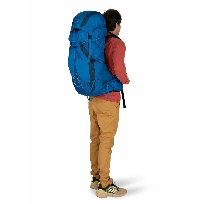 Person wearing a large blue backpack on a white background