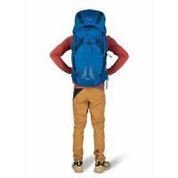 Person wearing a blue Osprey backpack on a white background