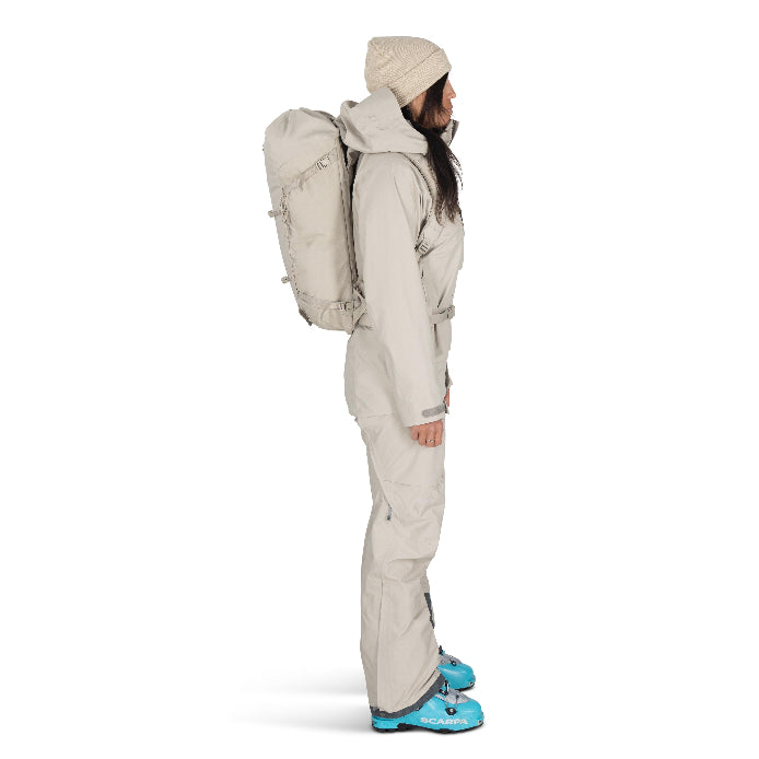 Person wearing a beige winter suit with a backpack on a white background
