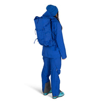 Person wearing a blue hiking outfit with a backpack on a white background