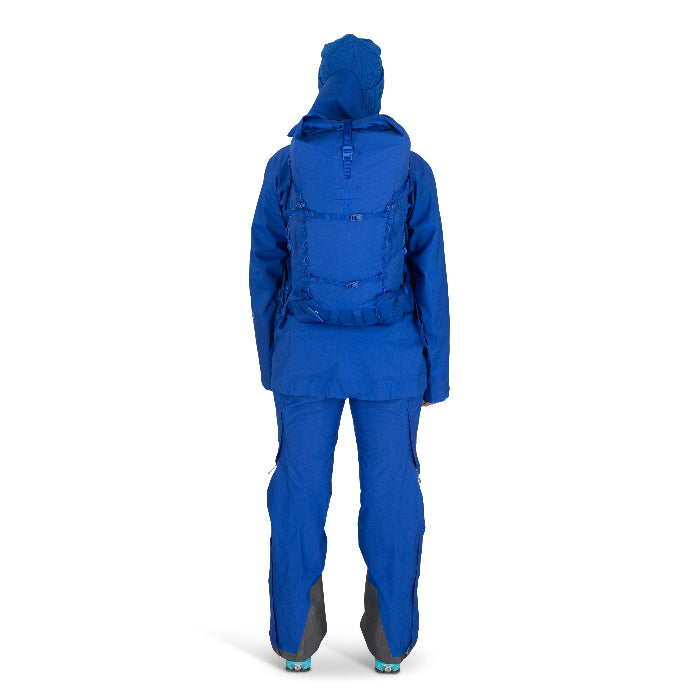 Person wearing a blue raincoat and pants with a backpack on a white background