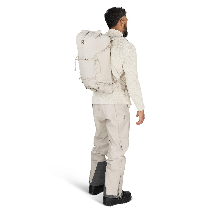 Man wearing a beige backpack and hiking pants on a white background