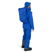 Person wearing a blue snowsuit with a large backpack on a white background