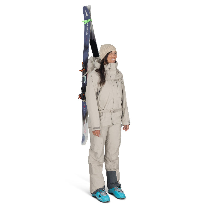 Person wearing a beige ski suit with skis on a white background