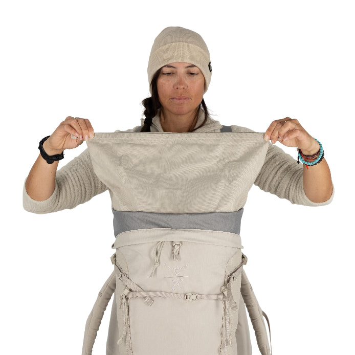 Person wearing a beige outfit with multiple straps on a white background