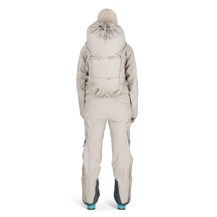 Person wearing a beige snowsuit with a hood on a white background
