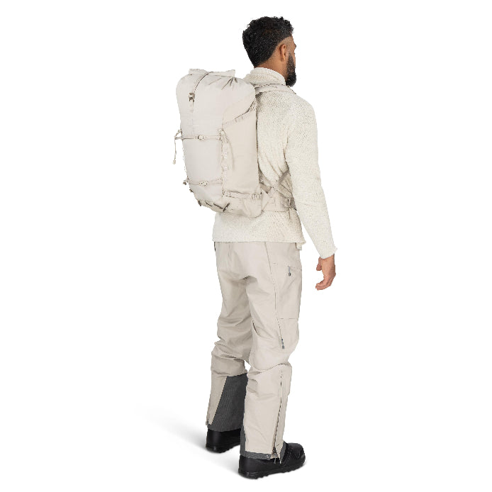 Man wearing a beige backpack and hiking pants on a white background