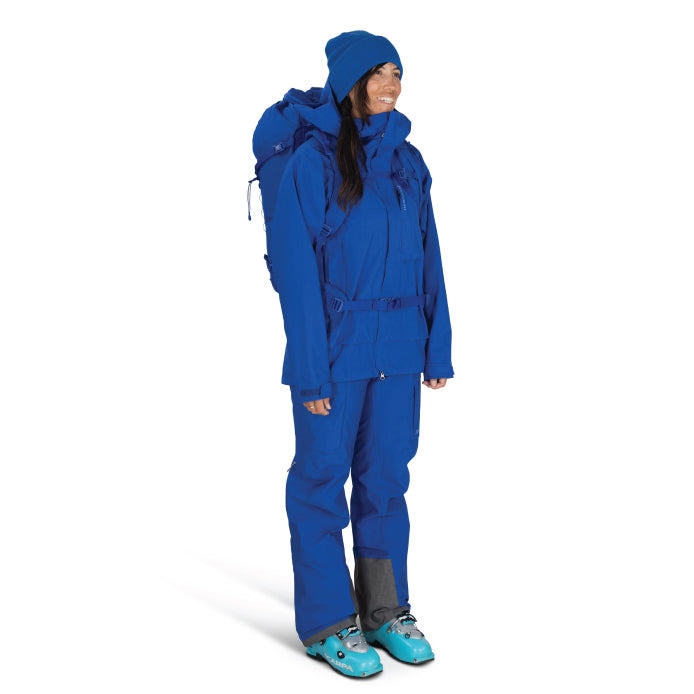 Person wearing a blue snowsuit with a backpack on a white background