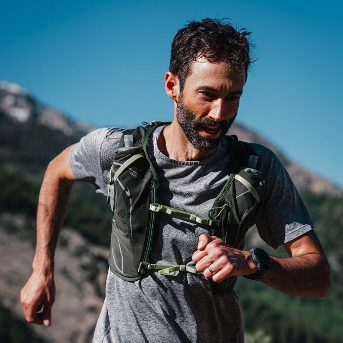 Man running outdoors with a mountainous background