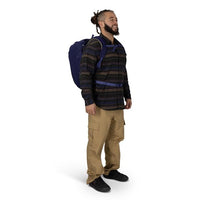 Blue travel backpack worn on back with padded shoulder straps