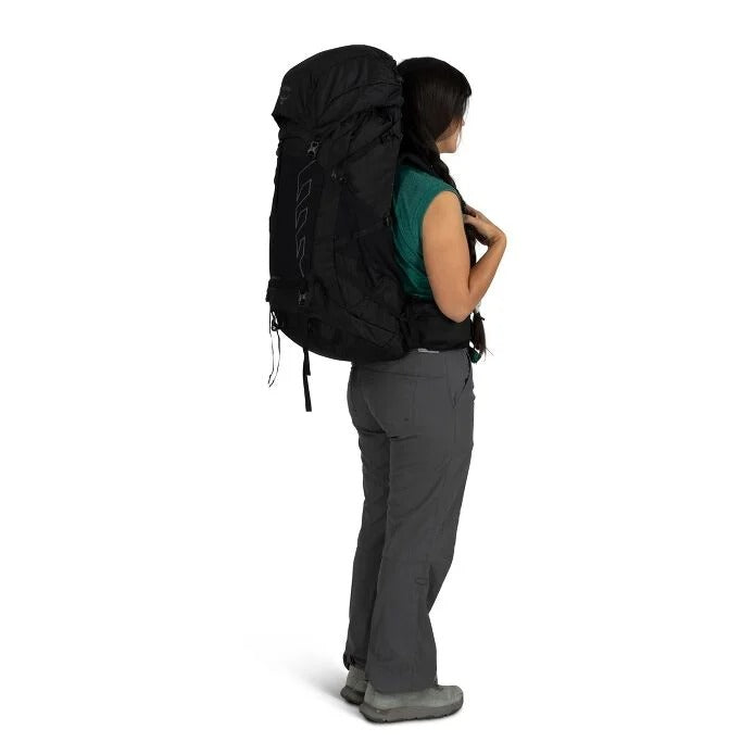 Person wearing a large black backpack on a white background