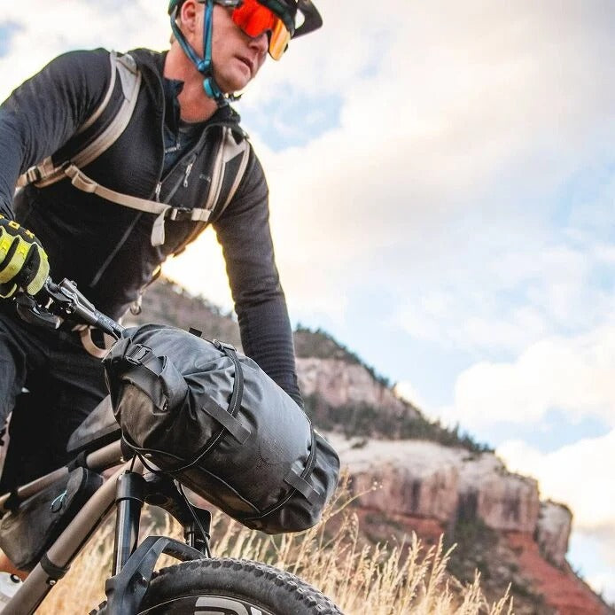 Person riding a mountain bike with scenic mountains in the background