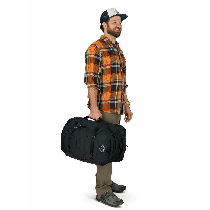 Man holding a black duffel bag against a white background