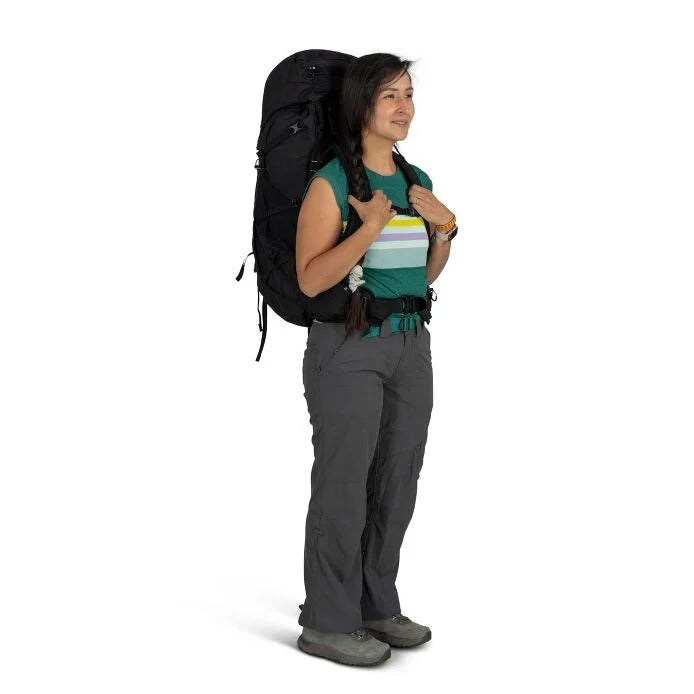 Person wearing a large black backpack on a white background