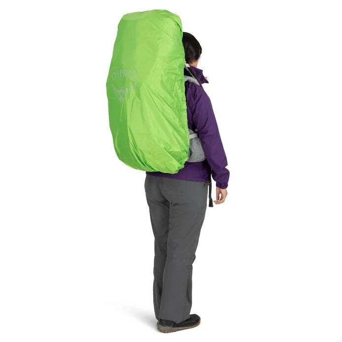 Person wearing a bright green backpack on a white background