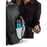 Person opening a black backpack with a blue water bottle and car key visible.