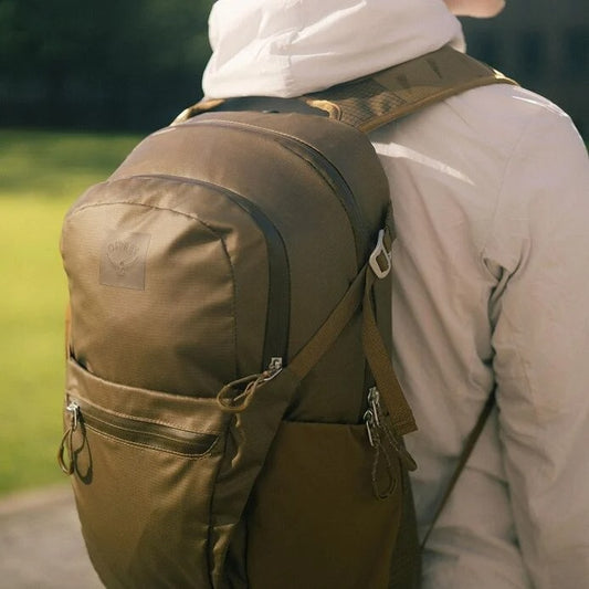 Person wearing a brown backpack outdoors