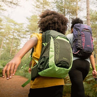 Two people hiking in a forest with backpacks on