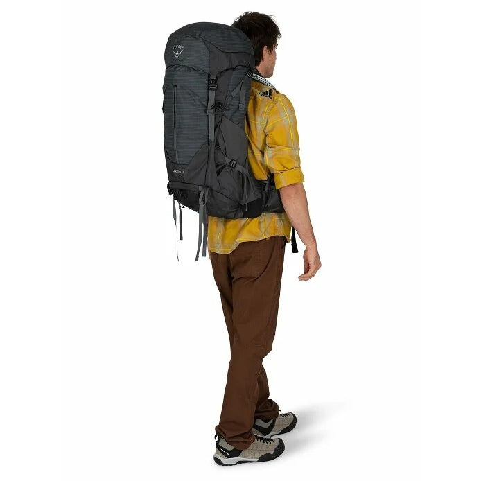 Person wearing a large gray backpack on a white background