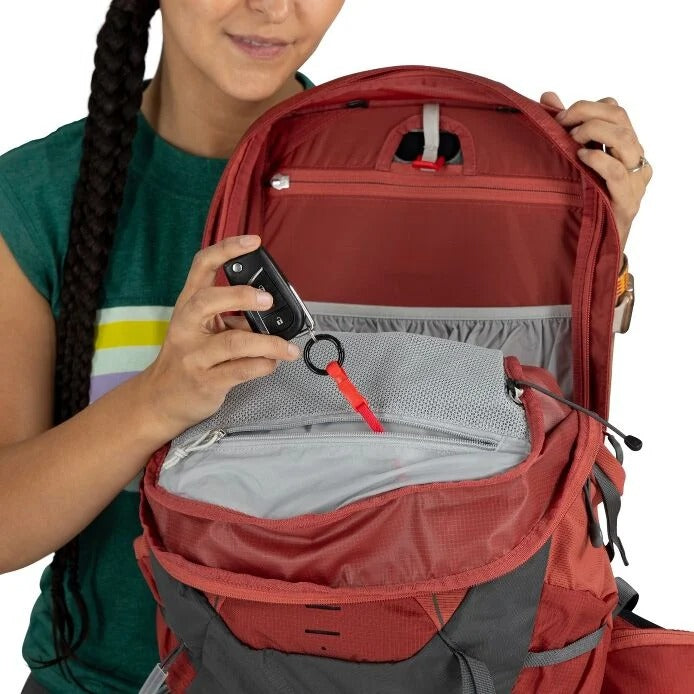 Person holding a red backpack with a clear view of its interior.